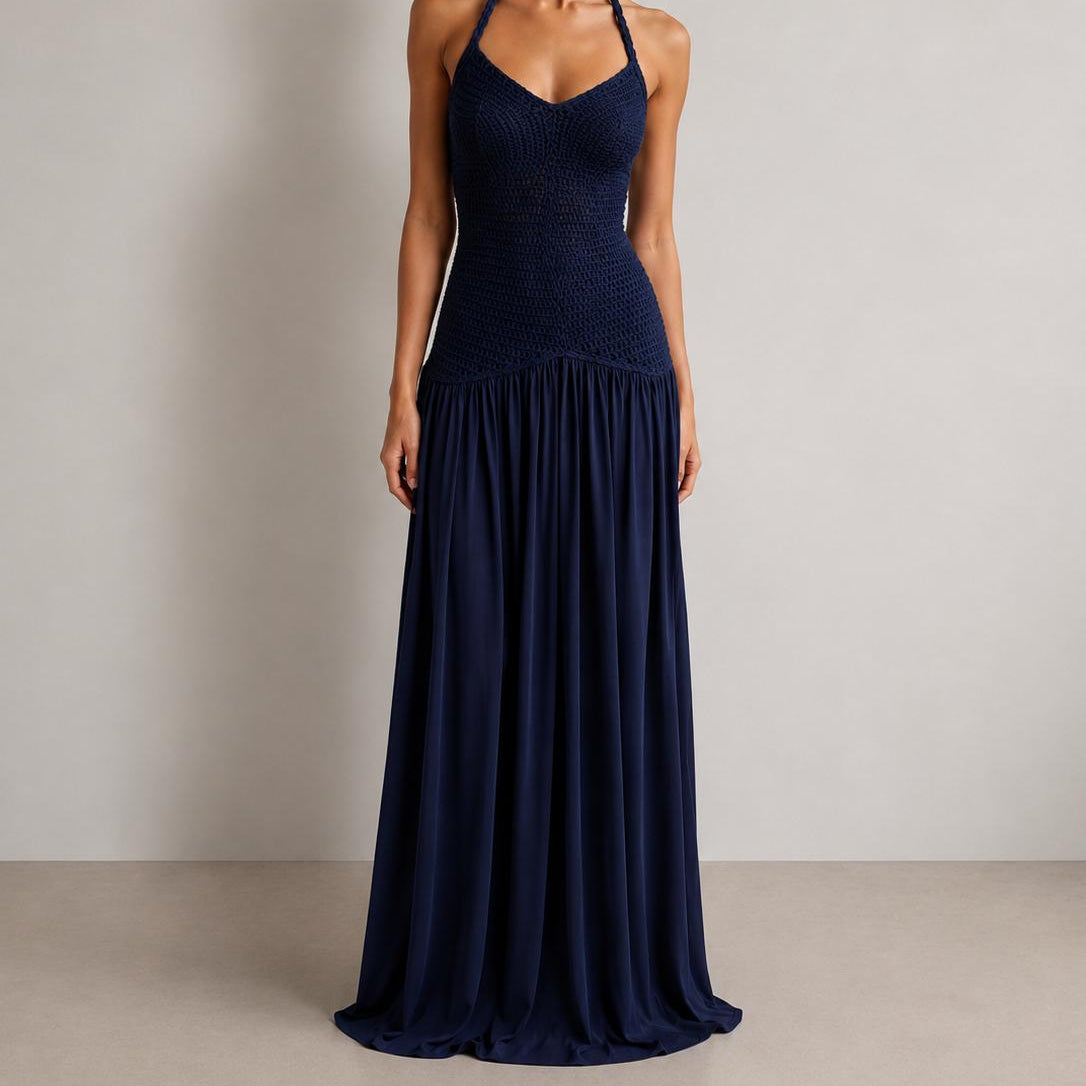 Woman wearing a navy blue halter neck dress against a plain background